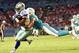 Aug 23, 2014; Miami Gardens, FL, USA; Miami Dolphins cornerback Brent Grimes (21) tackles Dallas Cowboys wide receiver Terrance Williams (83) in the second quarter of the game at Sun Life Stadium. Mandatory Credit: Brad Barr-USA TODAY Sports