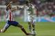 Real Madrid's Angel Di Maria, right, duels for the ball with Atletico Madrid's Juan Fran during a Spanish Super Cup soccer match at Santiago Bernabeu stadium in Madrid, Spain, Tuesday, Aug. 19, 2014 . (AP Photo/Daniel Ochoa de Olza)
