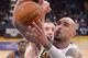 Memphis Grizzlies guard Nick Calathes, left, blocks the shot of Los Angeles Lakers center Robert Sacre during the second half of an NBA basketball game, Sunday, April 13, 2014, in Los Angeles. The Grizzlies won 102-90. (AP Photo/Mark J. Terrill)