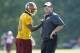 Washington Redskins quarterback Robert Griffin III, left, laughs with head coach Jay Gruden during an NFL football minicamp, Tuesday, June 17, 2014, in Ashburn, Va. (AP Photo/Nick Wass)