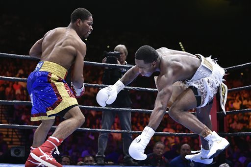 Shawn Porter, left, knocks Adrien Broner off-balance during a welterweight fight on Saturday, June 20, 2015, in Las Vegas. Porter won by unanimous decision after a 12-round bout. (AP Photo/David Becker)