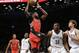 Toronto Raptors' Amir Johnson (15) shoots over Brooklyn Nets' Thaddeus Young (30) and Brook Lopez (11) during the first half of an NBA basketball game Friday, April 3, 2015, in New York. (AP Photo/Frank Franklin II)