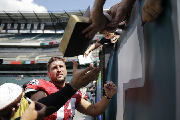 Tim Tebow Signs Fan's Bible at Eagles Training Camp