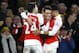 Arsenal's Mesut Ozil, centre, celebrates with Hector Bellerin, left, and Alex Oxlade-Chamberlain, right, after he scores a goal during the English Premier League soccer match between Arsenal and Bournemouth at Emirates stadium in London, Monday, Dec. 28, 2015. (AP Photo/Kirsty Wigglesworth)