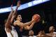 Virginia's Malcolm Brogdon (15) puts up a shot against Georgia Tech's Charles Mitchell, from left, Marcus Georges-Hunt, and James White in the first half of an NCAA college basketball game Saturday, Jan. 9, 2016, in Atlanta. (AP Photo/David Goldman)