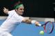 Roger Federer of Switzerland makes a backhand return to Alexandr Dolgopolov of Ukraine during their second round match at the Australian Open tennis championships in Melbourne, Australia, Wednesday, Jan. 20, 2016.(AP Photo/Vincent Thian)
