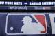 Rain drops cover a baseball logo before Game 1 of the Major League Baseball World Series between the New York Mets and Kansas City Royals, Tuesday, Oct. 27, 2015, in Kansas City, Mo. (AP Photo/Matt Slocum)