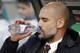 Bayern's head coach Pep Guardiola drinks as he arrives for the German Bundesliga soccer match between Hannover 96 and FC Bayern Munich in Hannover, Germany, Saturday, Dec. 19, 2015. (AP Photo/Michael Sohn)