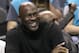 Charlotte Hornets owner Michael Jordan smiles as he watches his team in the first half of an NBA basketball game against the Detroit Pistons in Charlotte, N.C., Monday, Dec. 7, 2015. (AP Photo/Chuck Burton)