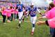 Buffalo Bills free safety Corey Graham (20) and tackle Cyrus Kouandjio (71) run near women wearing pink in observance of Breast Cancer Awareness Month prior to an NFL football game against the New York Giants, Sunday, Oct. 4, 2015, in Orchard Park, N.Y. (AP Photo/Bill Wippert)