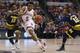 Indiana's Troy Williams (5) drives between Michigan's Derrick Walton Jr. (10) and Muhammad-Ali Abdur-Rahkman (12) in the first half of an NCAA college basketball game in the quarterfinals at the Big Ten Conference tournament, Friday, March 11, 2016, in Indianapolis. (AP Photo/Kiichiro Sato)