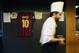 An employee of 'El Celler de Can Roca' walks past various items signed by famous customers, including a jersey of football player Lionel Messi, in the restaurant's kitchen in Girona on April 30, 2013. Spain's El Celler de Can Roca seized the title of the world's best restaurant from Denmark's Noma on April 29, one month after dozens of people came down with a bout of food poisoning from the Copenhagen eatery. The restaurant in Girona, run by three brothers and known for its dishes based on perfumes, had spent two years as runner-up on the World's 50 Best Restaurants list compiled for a 12th year by more than 900 international experts for Britain's Restaurant magazine. AFP PHOTO / QUIQUE GARCIA (Photo credit should read QUIQUE GARCIA/AFP/Getty Images)