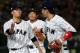 Japanese starter Kodai Senga (L) is congratulated by his teamates after the top of the first inning during the World Baseball Classic Pool E second round match between Israel and Japan at Tokyo Dome in Tokyo on March 15, 2017. / AFP PHOTO / TORU YAMANAKA (Photo credit should read TORU YAMANAKA/AFP/Getty Images)