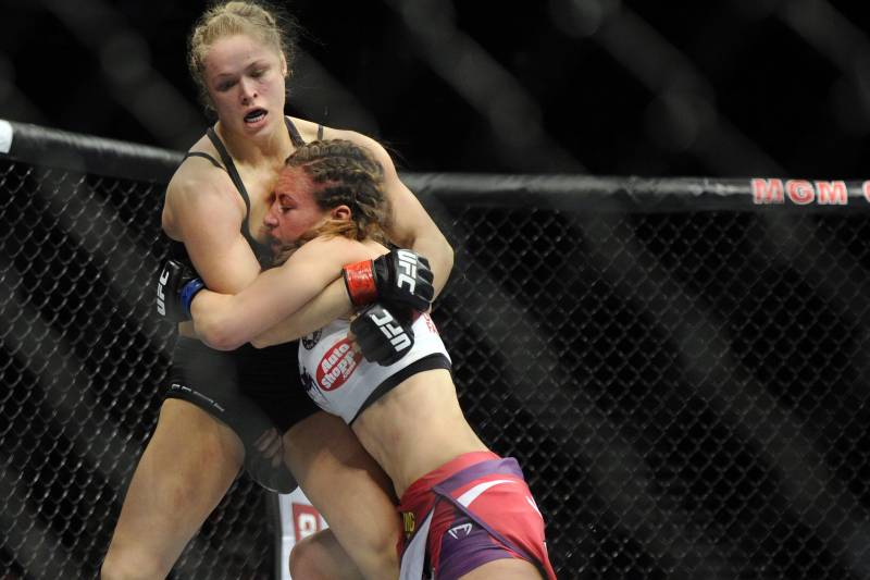 Ronda Rousey, left, of Venice, Calif., holds Miesha Tate of Yakima, Wash., during the UFC 168 mixed martial arts women's bantamweight title fight on Saturday, Dec. 28, 2013, in Las Vegas. Rousey won by a third round tap out. (AP Photo/David Becker)
