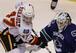 Calgary Flames' Jon Rheault, left, and Vancouver Canucks' Cory Schneider follow the puck during first period pre-season NHL hockey action in Vancouver, B.C., on Tuesday September 21, 2010. The teams are playing two split-squad games with one game in Vanco
