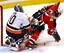 New Jersey Devils' Patrik Elias, of the Czech Republic, loses the puck as he is checked into New York Islanders goaltender Garth Snow, left, by Eric Cairns, right rear, during the third period Wednesday night, Sept. 24, 2003, in East Rutherford, N.J. The