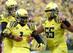 Hroniss Grasu (right) celebrates with Josh Huff and Marcus Mariota