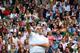 Roger Federer is a blur as he launches for a signature overhead, Wimbledon.