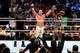 John Cena has his hands held high by Mark Henry and Big E Langston.