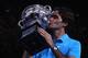 Roger Federer kisses his fourth Australian Open trophy in 2010.