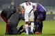Giuseppe Rossi (No. 49) is checked on by Fiorentina trainers and Livorno's Leandro Greco.