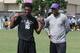 Cornerback prospect Xavier Lewis stands with LSU defensive back coach Corey Raymond.