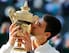 Novak Djokovic kisses his trophy after winning the 2014 Wimbledon men's final.