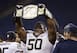 Tyrone Ezell holds up a replica WWE title at a college bowl game.