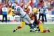 LANDOVER, MD - SEPTEMBER 22: Brandon Meriweather #31 and Josh Wilson #26 of the Washington Redskins tackle Calvin Johnson #81 of the Detroit Lions in the second quarter at FedExField on September 22, 2013 in Landover, Maryland. (Photo by Greg Fiume/Gett