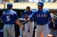 OAKLAND, CA - AUGUST 04: Ian Kensler #5 of the Texas Rangers is congratulated by Nelson Cruz #17 after Kensler scored in the first inning against the Oakland Athletics at O.co Coliseum on August 4, 2013 in Oakland, California. Kensler scored on an RBI si