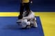 Jacare is in Maia's butterfly guard, and Maia is attacking Jacare's left arm with both hands.