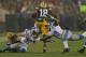 GREEN BAY, WI - DECEMBER 09: Randall Cobb #18 of the Green Bay Packers leaps between Don Carey #32 (L) and Ricardo Silva #39 of the Detroit Lions at Lambeau Field on December 9, 2012 in Green Bay, Wisconsin. The Packers defeated the Lions 27-20. (Photo by