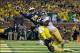 Sep 7, 2013; Ann Arbor, MI, USA; Michigan Wolverines quarterback Devin Gardner (98) throws while being tackled by Notre Dame Fighting Irish linebacker Prince Shembo (55) and safety Austin Collinsworth (28) in the fourth quarter at Michigan Stadium. Gardne