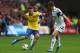 SWANSEA, WALES - SEPTEMBER 28: Mesut Oezil (L) of Arsenalruns at Ben Davies (R) of Swansea City during the Barclays Premier League match between Swansea City and Arsenal at the Liberty Stadium on September 28, 2013 in Swansea, Wales. (Photo by Michael S