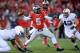 COLUMBUS, OH - OCTOBER 26: Quarterback Braxton Miller #5 of the Ohio State Buckeyes passes in the first half as Mike Hull #43 of the Penn State Nittany Lions closes in at Ohio Stadium on October 26, 2013 in Columbus, Ohio. Ohio State defeated Penn State