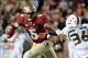 Nov 2, 2013; Tallahassee, FL, USA; Florida State Seminoles quarterback Jameis Winston (5) evades Miami Hurricanes linebacker Alex Figueroa (36) during the second half at Doak Campbell Stadium. Mandatory Credit: Melina Vastola-USA TODAY Sports