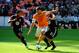 Oct 27, 2013; Washington, DC, USA; Houston Dynamo forward Will Bruin (12) moves the ball between DC United defender James Riley (2) and DC United defender Daniel Woolard (21) during the first half at Robert F. Kennedy Memorial. Mandatory Credit: Brad Mill