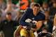 SOUTH BEND, IN - OCTOBER 19: Cam McDaniel #33 of the Notre Dame Fighting Irish gets tackeld after losing his helmet against the University of Southern California Trojans at Notre Dame Stadium on October 19, 2013 in South Bend, Indiana. Notre Dame defeated