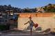 RIO DE JANEIRO, BRAZIL - NOVEMBER 02: A young boy plays football in the Mangueira pacified community, or shantytown, which is located close to the famed Maracana Stadium, on November 2, 2013 in Rio de Janeiro, Brazil. The favela was previously controlled