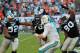 Nov 24, 2013; Miami Gardens, FL, USA; Carolina Panthers defensive tackle Dwan Edwards (left), guard Nate Chandler (center), and defensive end Frank Alexander (right) tackle Miami Dolphins quarterback Ryan Tannehill (17) during the second half at Sun Life