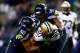 SEATTLE, WA - DECEMBER 02: Tight end Jimmy Graham #80 of the New Orleans Saints is tackled by outside linebacker K.J. Wright #50 and defensive tackle Tony McDaniel #99 of the Seattle Seahawks during a game at CenturyLink Field on December 2, 2013 in Seat