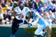 CHAPEL HILL, NC - NOVEMBER 30: Anthony Boone #7 of the Duke Blue Devils rolls ut under pressure from Jeff Schoettmer #34 of the North Carolina Tar Heels during play at Kenan Stadium on November 30, 2013 in Chapel Hill, North Carolina. (Photo by Grant Ha