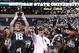 Dec 7, 2013; Indianapolis, IN, USA; Michigan State Spartans quarterback Connor Cook (18) receives the MVP trophy as coach Mark Dantonio reacts after defeating the Ohio State Buckeyes during the Big Ten Championship game at Lucas Oil Stadium. Michigan Stat