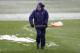 LONDON, ENGLAND - JANUARY 20: Groundsman clear snow from the pitch ahead of the Barclays Premier League match between Tottenham Hotspur and Manchester United at White Hart Lane on January 20, 2013 in London, England. (Photo by Clive Mason/Getty Images)