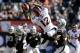 OAKLAND, CA - DECEMBER 29: Andre Caldwell #12 of the Denver Broncos catches a pass over Chimdi Chekwa #35 and Charles Woodson #24 of the Oakland Raiders during the first quarter at O.co Coliseum on December 29, 2013 in Oakland, California. (Photo by The