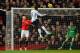 Emmanuel Adebayor heads home the opening goal against Manchester United.