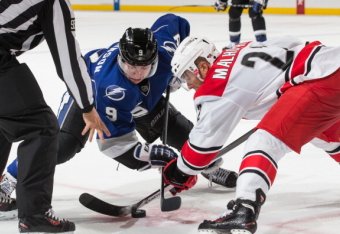TAMPA, FL - DECEMBER 21: Tyler Johnson #9 of the Tampa Bay Lightning takes the face-off against Manny Malhotra #22 of the Carolina Hurricanes at the Tampa Bay Times Forum on December 21, 2013 in Tampa, Florida.  (Photo by Scott Audette/NHLI via Getty Imag