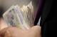 CHICHESTER, ENGLAND - JULY 27: A bookmaker holds bank notes at Goodwood racecourse on July 27, 2011 in Chichester, England. (Photo by Alan Crowhurst/Getty Images)