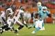 Aug 24, 2013; Miami Gardens, FL, USA; Miami Dolphins running back Lamar Miller (26) is tackled by Tampa Bay Buccaneers cornerback Michael Adams (21) during the first quarter at Sun Life Stadium. Mandatory Credit: Steve Mitchell-USA TODAY Sports
