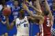 LAWRENCE, KS - FEBRUARY 24: Joel Embiid #21 of the Kansas Jayhawks looks to pass the ball against D.J. Bennett #31 of the Oklahoma Sooners in the second half at Allen Fieldhouse on February 24, 2014 in Lawrence, Kansas. Kansas won 83-75. (Photo by Ed Zu